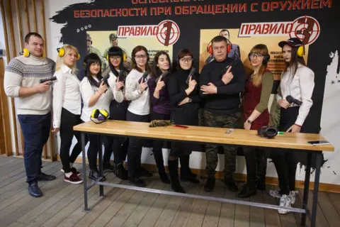 Участники корпоратива у стола для инструктажа